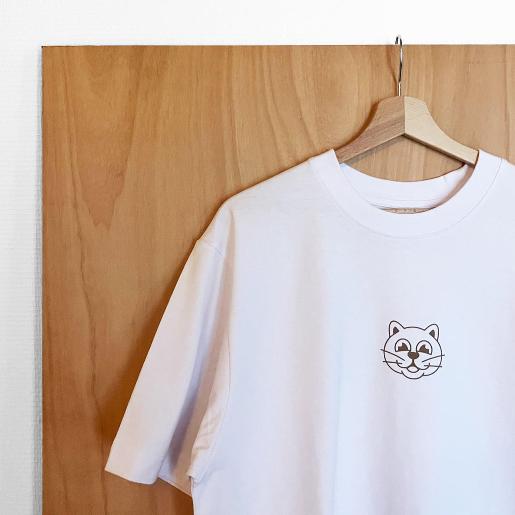 Tee-shirt blanc et marron Herbe à Chat CBD, style décontracté avec logo HAC CBD visible sur le devant.